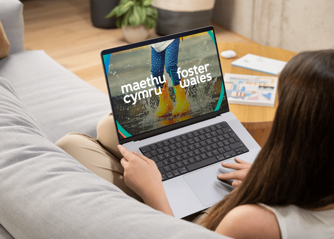 woman sitting on sofa with laptop on knee